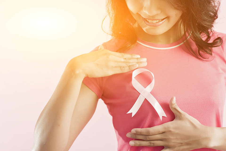 A soft glow upon a woman with a pink ribbon on